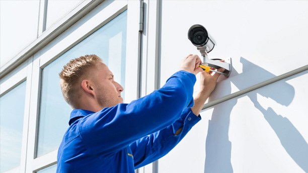 Security technician installing a surveillance camera for residential and commercial safety